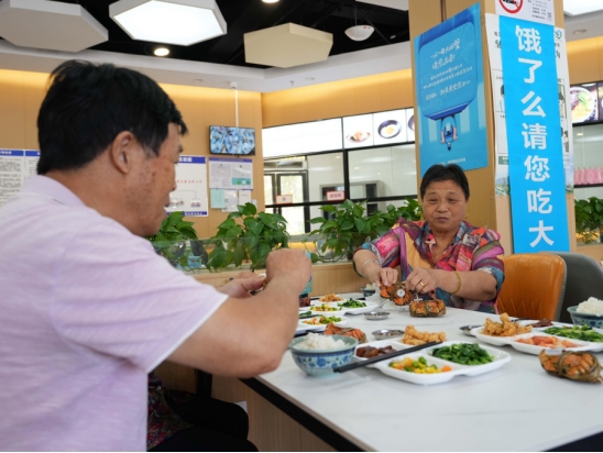 Elderly residents eat in a community cafeteria